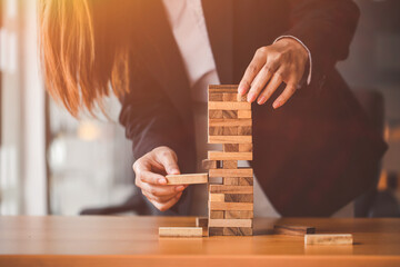 Woman's hand stacking wooden blocks  on a tower,. Business Planning,risk, strategy,development and...