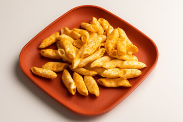Crispy penne pasta shaped salty. Fast food or junk food snacks unhealthy concept.