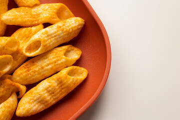Crispy penne pasta shaped salty. Fast food or junk food snacks unhealthy concept.