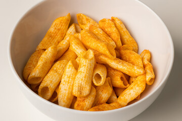 Crispy penne pasta shaped salty. Fast food or junk food snacks unhealthy concept.