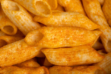 Crispy penne pasta shaped salty. Fast food or junk food snacks unhealthy concept.