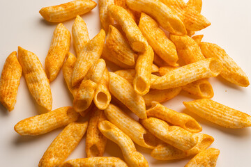 Crispy penne pasta shaped salty. Fast food or junk food snacks unhealthy concept.