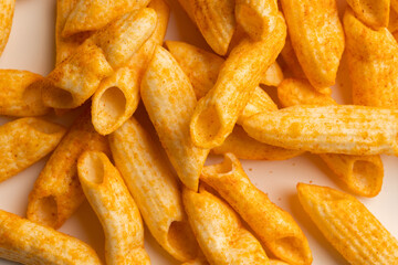 Crispy penne pasta shaped salty. Fast food or junk food snacks unhealthy concept.
