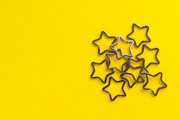 Obraz premium Heap of shiny metal split key rings for keychains. Chromium plated keychain clasp on yellow background. Flat lay, top view with copy space.
