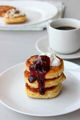 Breakfast of cheesecakes on a plate with sour cream.