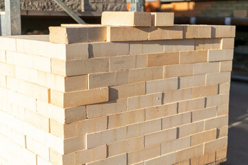 new brick block construction material on pallet. Beige bricks in the package, background