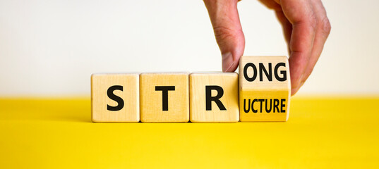 Strong structure symbol. Businessman turns a wooden cube with words 'strong structure'. Beautiful...