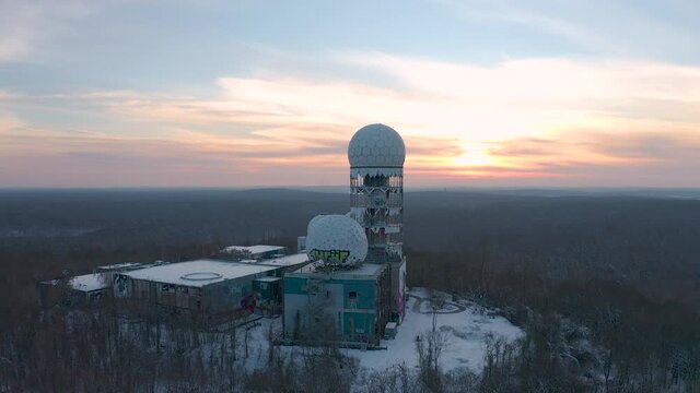 abandoned observatory station on a hill in winter during sunset