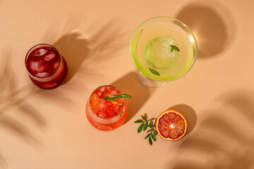 Popular summer ice alcoholic cocktails served under the summer sun light. Trendy style with shadows.