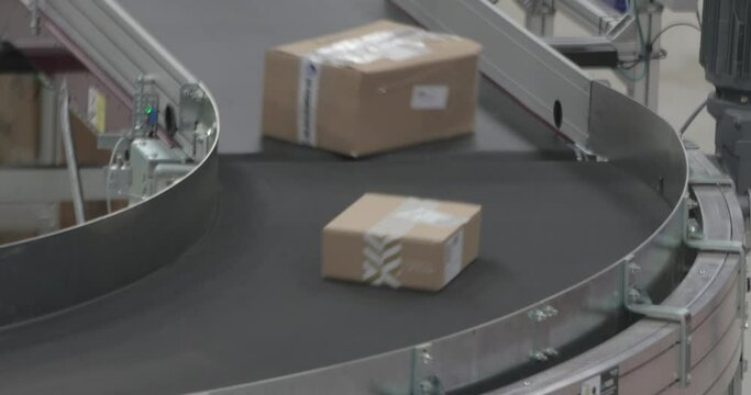 Boxes Parcels Packages at Fast Conveyer in Distribution Warehouse