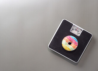 Donut on the floor scales on gray background.