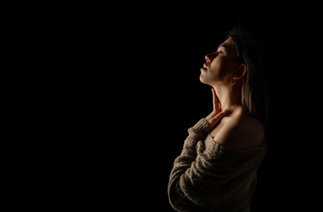 Portrait of beautiful young woman isolated on black background. Horizontal shot, copy space for text message.