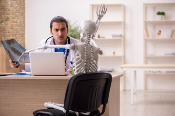 Young male doctor radiologist and skeleton patient in the clinic