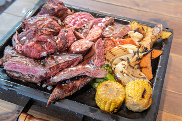 Complete grill of Argentine Asado of meat with vegetables and served in Brasero