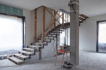 Repairs in the building. Building with a metal staircase at the time of renovation. Construction site in the house without people. Construction of a new house. Construction and architecture.