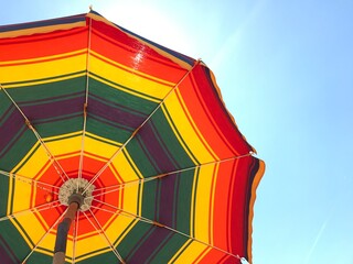 Obraz premium Rainbow umbrella against a clear blue sky