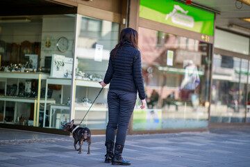 Frau mit Hund in der Stadt beim Spazierengehen am Wochenende