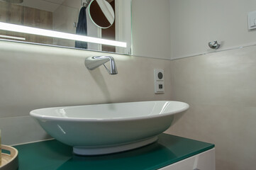 Detail of a vanity unit. Sink mounted on a cabinet, with a wall tap. Detailaufnahme einer Waschtischanlage. Waschbecken auf einen Schrank montiert, mit einer Wandarmatur
