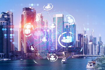 Skyscrapers of Dubai business downtown. International hub of trading and financial services. Social network icons hologram, concept of human resources. Double exposure. Dubai Canal waterfront.