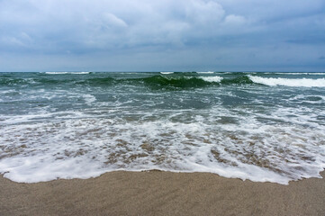 The sea is agitated. Huge waves of the sea. Cloudy landscape on the sea.