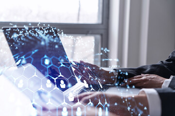 Two HR specialists analyzing the recruitment market using laptop to boost the intern program at international consulting company. Social networking hologram icons.