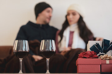 caucasian couple talking and sitting on couch at home together and looking out of the window (focus at gift box)(focus at gift box)