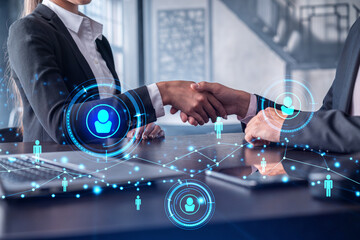 Recruitment concept of hiring of a new talented specialists for international company. Handshake as a concept of agreement to sign an employment contract. Social media hologram icons.
