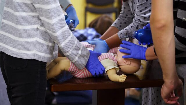 Training for first aid. Practitioners doing cardiopulmonary resuscitation on baby dummies. Training practice of a chest compression and breathing. Education of medicine.