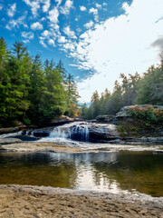 Obraz premium Swallow Falls State Park in the fall in the mountains of Maryland with the creek and waterfalls flowing, cascading in nature, fall foliage and trees to create the perfect fall water landscapes.