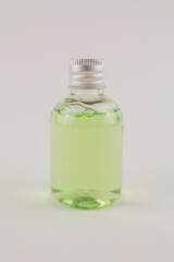 light green shampoo in a transparent bottle on a white background