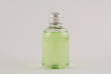light green shampoo in a transparent bottle on a white background
