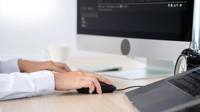 Young Asian woman Programmer Typing code working with computer at table, coding cyberspace and Web Development Concept