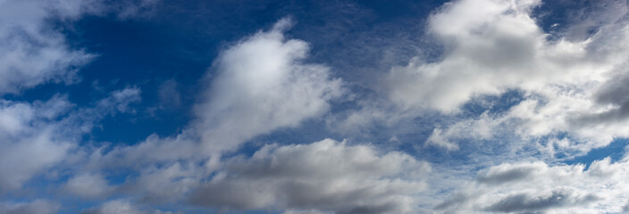 Blurred white clouds over blue sky and sunny day. Panorama of winter sky