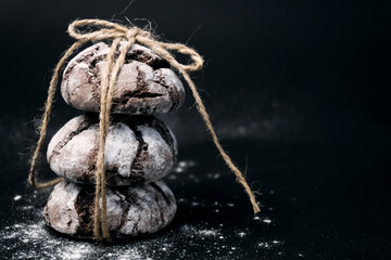 Chocolate Crinkles. Chocolate cookies in powdered sugar on black background