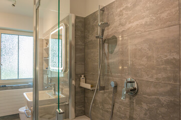 Partial view of a bathroom, with a tub shower and sink. Teilansicht eines Badezimmers, mit Wanne Dusche und Waschbecken