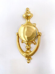 Golden door knocker on white door