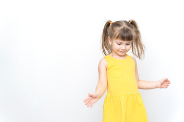 emotional little girl in yellow dress posing on grey background