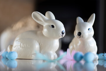 Easter concept. Two decorative rabbits and blue decorative eggs on a light background.