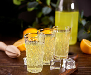 Italian drink lemon liqueur limoncello in glasses on the wooden table