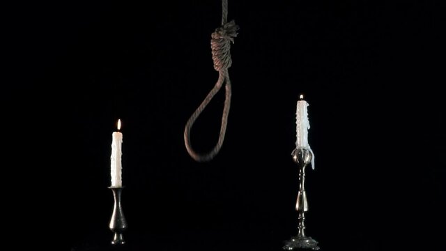 suicide loop. the gallows. the loop dangles. Rope noose with hangman knot in front of dark background