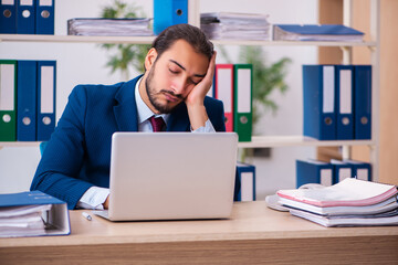 Fototapeta premium Young male employee and too many work in the office