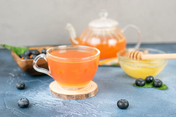 Obraz na płótnie Canvas Wild berry tea with honey in a glass teapot
