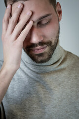 Portrait of a young man touching his forehead to focus or because of an headache 
