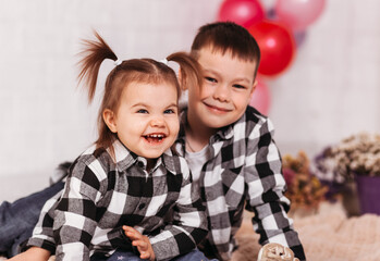 Happy boy and girl brother and sister in festive interior