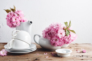 Obraz na płótnie Canvas White cups, teapot and Japanese cherry blossoms.