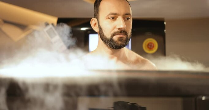 Adult man during cryotherapy in a special capsule. Wellness in a medical spa. Cryo sauna