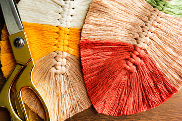Colorful leaf motif from macrame threads and scissors.
Macrame leaves in yellow, white, green, brick and beige Colors.leaves made with colored macrame threads