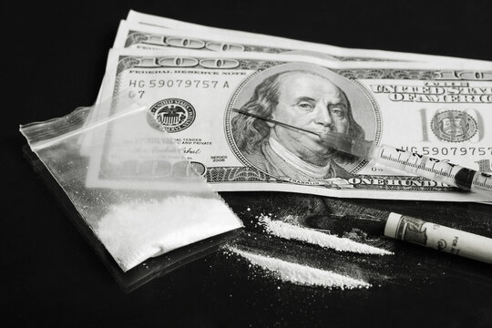 Black and white picture of cocaine rows near dollar bills. Drugs dealer taking cocaine