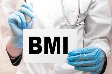 The doctor's blue - gloved hands show the word BMI - . a gloved hand on a white background. Medical concept. the medicine