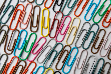 Many colorful paper clips on a home office desk for stationary design as colorful pattern to tidy desk, papers and paperwork to attach attachments to files and documents or collection of office supply